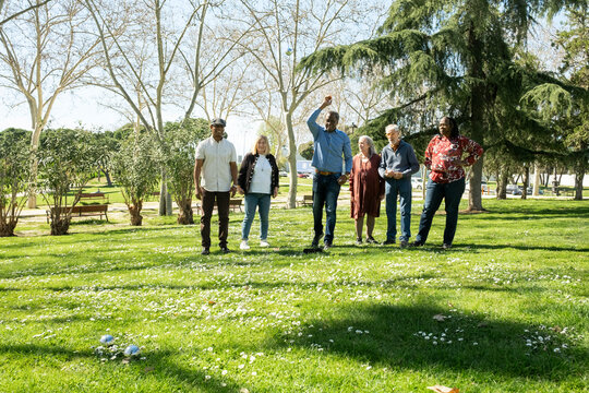 Diverse Group of Senior friends playing bocce in park
