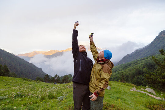 Friends try to catch mobile signal in the mountains