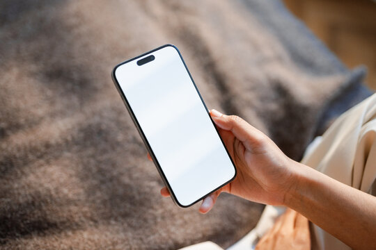 A white-screen mobile phone in a woman's hand