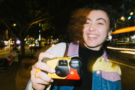 Laughing woman with disposable camera