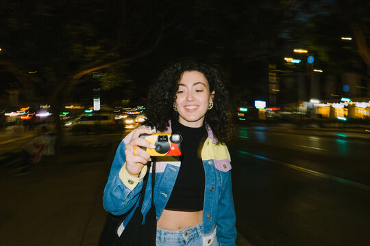 Woman looking at disposable camera