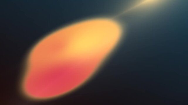 An abstract, soft-focused image featuring a glowing, elongated shape in warm orange and red hues against a dark background with a bright light flare.