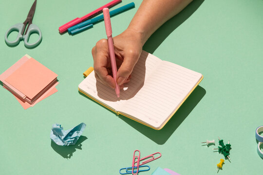 A female hand writes in an open notebook