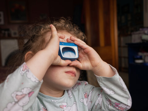 A girl looks through a slideshow toy