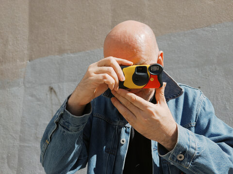 Man using a camera to capture a moment in an urban setting