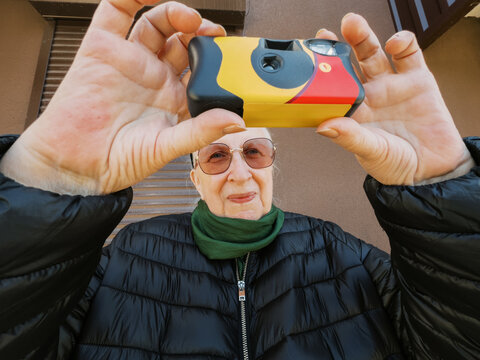Person using a camera outside a building during daylight 