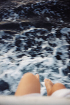 Feet Dangling Over the Ocean Waves
