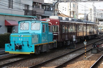 Obraz premium 青いモーターカーに牽引される阪急電車