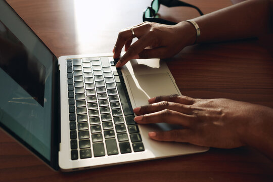 Closeup of anonymous woman hands typing on laptop keyboard