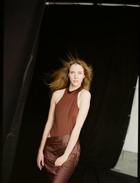 Elegant Fashion Model Poses in Chic Attire Against Dark Backdrop