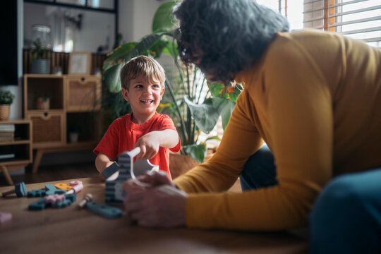 Grandmother and grandson playing with wooden toys at home