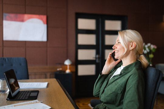 A woman is talking on a mobile phone in the office