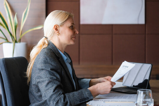A woman studies documents sitting at her desk