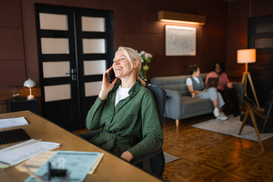 A woman is talking on a mobile phone in the office