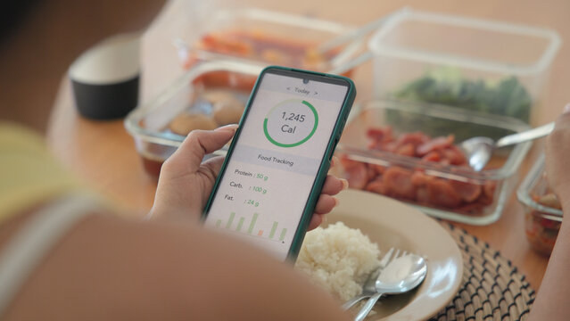 Young adult black asia people active gen z using AI phone record data daily meal tracker clean food diet app control. Asian Smart living care happy life goal routine plan lunch time home dining table.