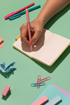 A female hand writes in an open notebook 
