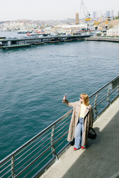 A woman takes a selfie on the city embankment