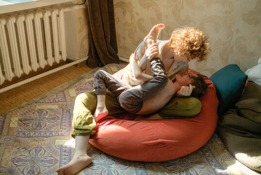 mother hugs son sitting on the floor