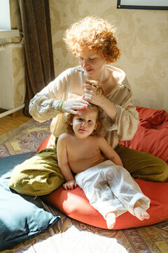
woman combing her son's hair