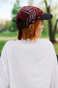 Young woman in the park wearing a cap and white long sleeve