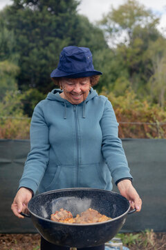 Woman holding pot with cooked meat