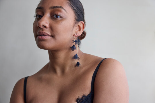 Woman posing in lace top and earrings