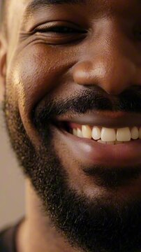 Close up of a bearded man smiling gently in a bright indoor setting, happiness and contentment, male lifestyle, friendly face.