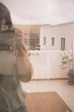 Film photography of reflection of woman on window