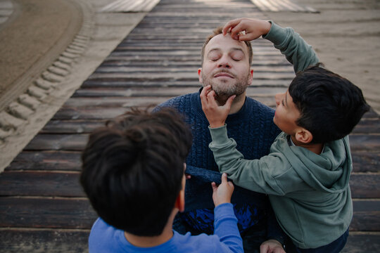 Father Enjoying Time with Children Having Fun on a Wooden Deck