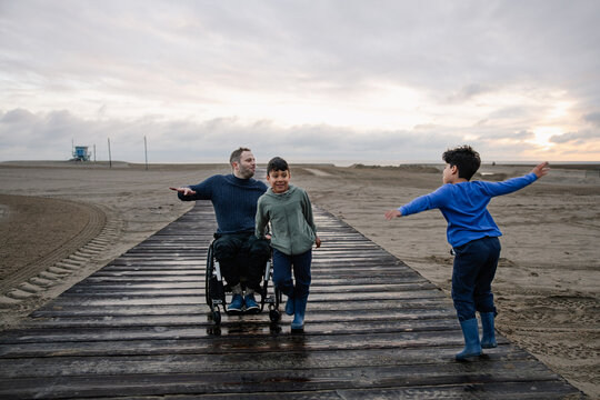 Father and Sons Enjoy Relaxing Time Together on a Sunset Beach Walk