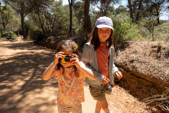 Children Exploring Nature with Camera on Sunny Day