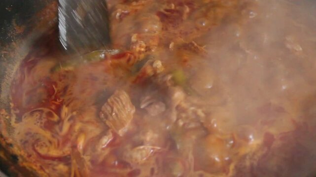 cooking curry in a pan with beef and spices