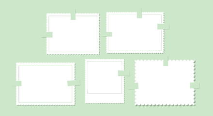Collection of blank white vintage photo frames with scalloped edges attached to a light green background with small pieces of masking tape.