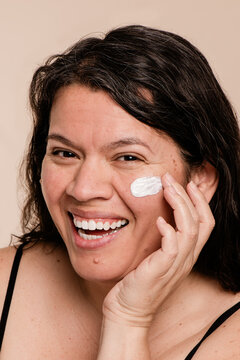 Laughing Beauty Portrait of Model with Moisturizer on Cheek