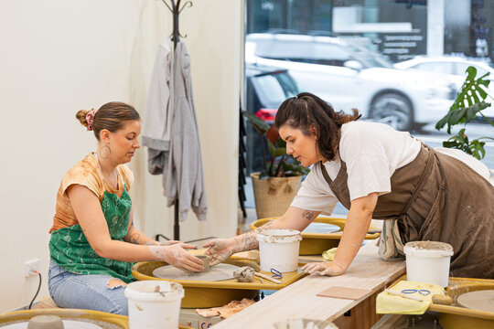 Women teamwork in pottery class enhancing skills