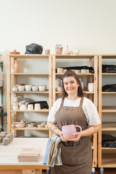Cheerful artist presents a handmade ceramic piece