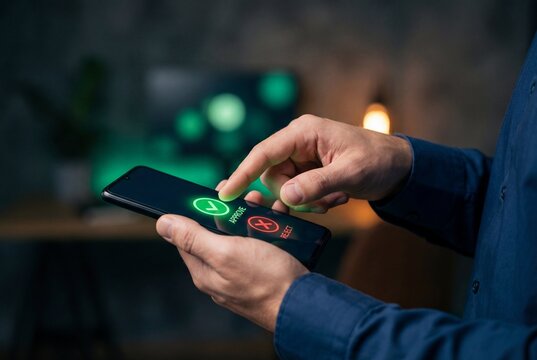 Male hands holding smartphone and finger hovering over green button