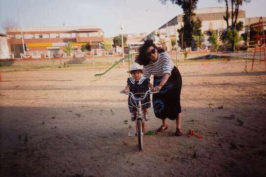 Analog film portrait of baby girl and mother riding a bike