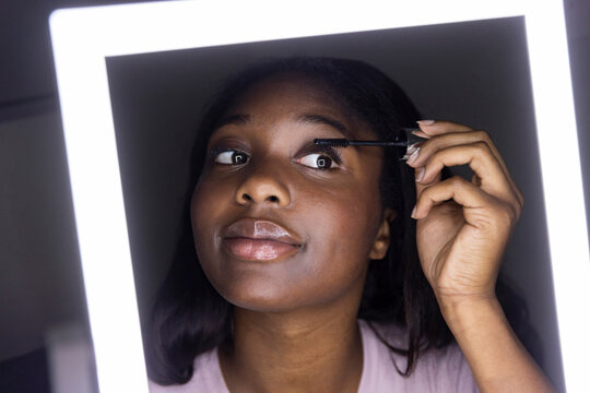  Teen apply mascara mirror portrait 