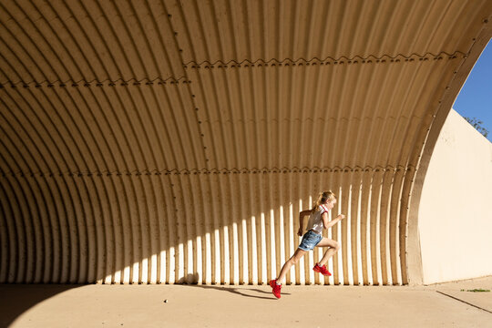 Young girl  athlete running in tunnel 