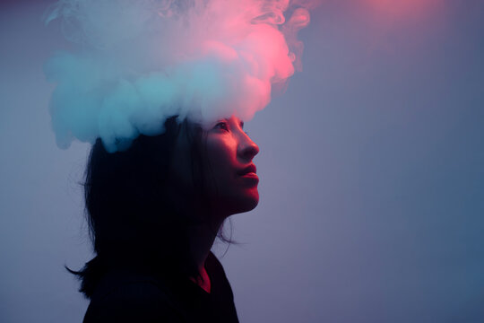 Surreal portrait of woman with smoke on head