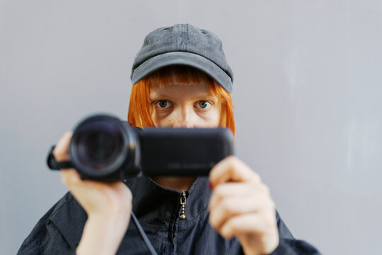 Young Woman Holding a Camera with Captivating Expression