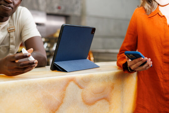 Woman Prepares for Mobile Payment in Caf&eacute;