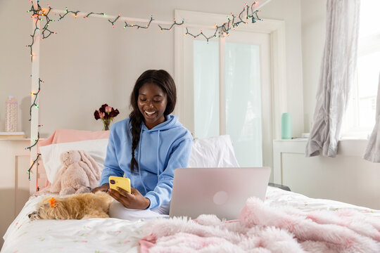 Teen texting on cellphone  pet dog 