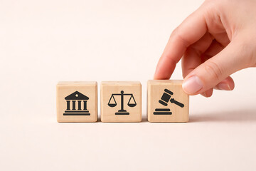 Naklejka premium Wooden blocks with court building scales of justice and gavel icons for legal system and law firm services or government legislation and justice for all