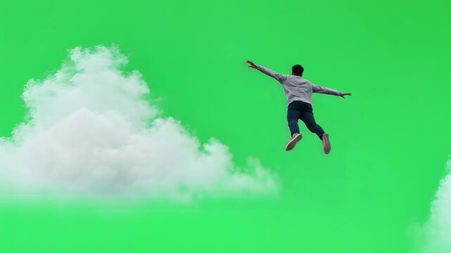 Man falling through clouds on green screen background.