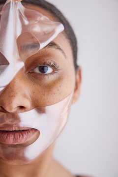 Woman peeling off cosmetic face mask 