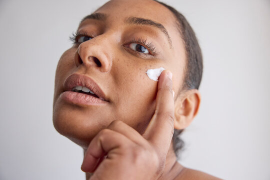 Model applying skincare cream on her face