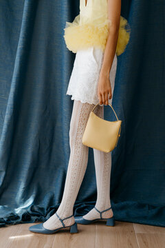 Anonymous woman holding yellow handbag in style