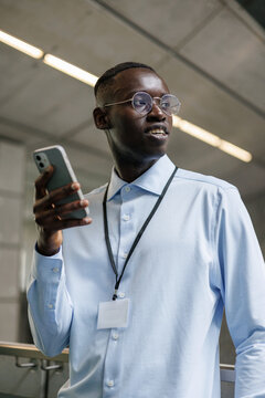 Confident Professional Man Using Smartphone Indoors